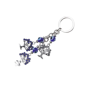 Silver Evil Eye keychain with Tree of Life charms and blue beads on a white background