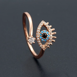 Macro shot of rose gold evil eye ring featuring blue and black stones with clear zircon accents