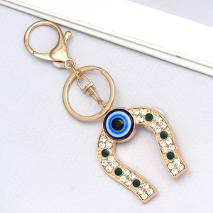 Detailed close-up of golden horseshoe evil eye keychain with sparkling rhinestones