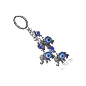 Détail du porte-clés œil bleu avec des pendentifs éléphants et des motifs ajourés fins