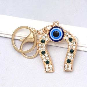 Macro shot of gold horseshoe keychain with evil eye pendant and sparkling rhinestones