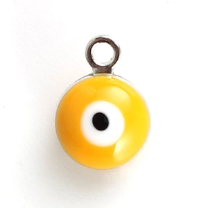 Macro view of a yellow Evil Eye charm with silver ring for DIY jewelry making