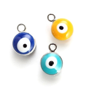 Detailed macro view of colorful evil eye pendants with metal base and enamel finish