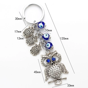 Vue détaillée du porte-clés hibou avec perles mauvais œil et texture métal