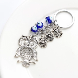 Détail des pendentifs chouette argentés et perles œil porte-bonheur sur le porte-clés