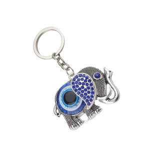 Détail macro du porte-clés éléphant avec œil porte-bonheur et strass bleus brillants