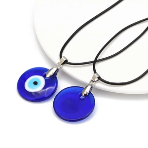 Handmade Evil Eye blue glass pendant necklaces with black rope chain on a white display