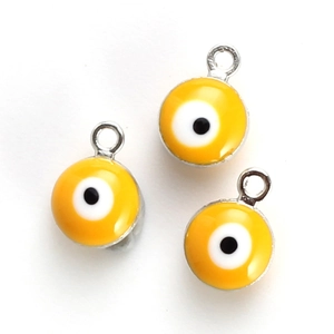 Detail of three yellow Evil Eye charms with silver hanging loops for DIY jewelry