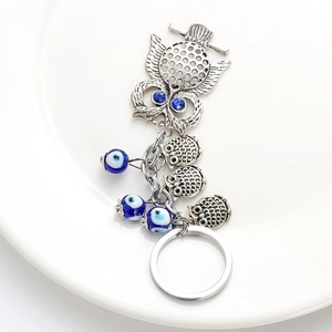 Détail du porte-clés hibou avec perles mauvais œil et strass bleus étincelants en métal