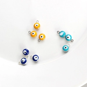 Detail view of colorful evil eye charms in blue and orange for DIY jewelry making