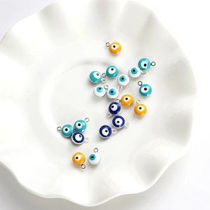 Detailed macro shot of assorted colorful evil eye charms with silver alloy frames on a dish