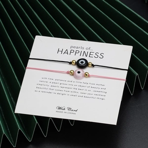 Detail von bösem Blick geflochtenen Paar-Armbändern in Schwarz und Rosa auf Karte