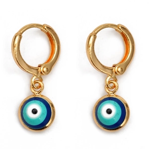Detailed view of golden hoop earrings with blue enamel evil eye charms on a white background