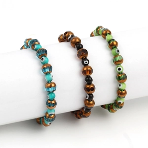 Macro detail of three bohemian evil eye beaded bracelets in blue, green, and black colors