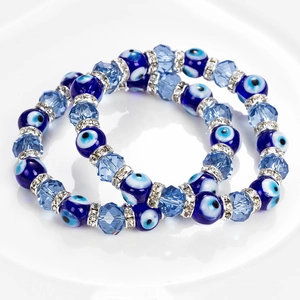 Détails de deux bracelets œil maléfique avec perles en cristal bleu et strass brillants