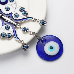 Close-up of a blue evil eye butterfly wall hanging with a large glass nazar pendant