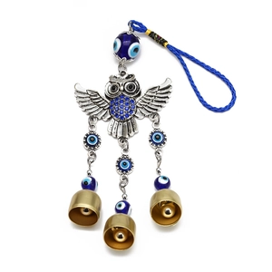 Detail of owl evil eye wall hanging with blue rhinestones and small metal bells