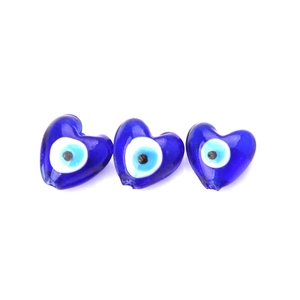Detailed macro view of three heart-shaped blue evil eye beads for DIY jewelry making