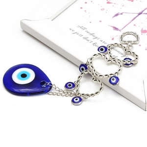 Dettaglio del portachiavi occhio blu a goccia con catena a cuore su sfondo estetico