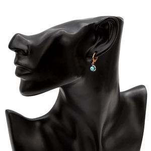 Detail showing gold Evil Eye hoop earring on black mannequin stand with enamel charm