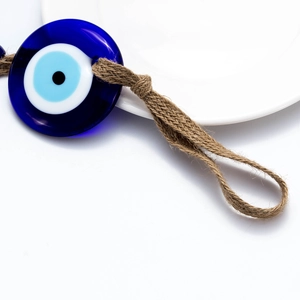 Detailed macro view showing a blue glass Evil Eye pendant with natural hemp rope texture