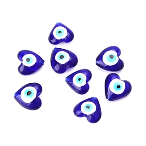 Macro detail of seven blue heart-shaped glass evil eye beads for DIY jewelry making