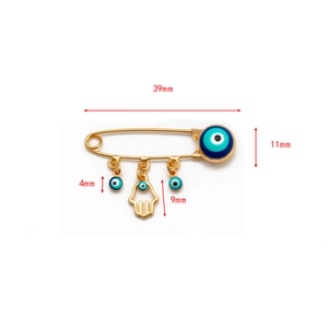 Detail view of Hamsa Hand and Evil Eye pendants on a golden pin with size labels