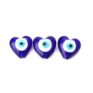 Close-up of three polished deep blue heart-shaped evil eye beads for DIY jewelry making