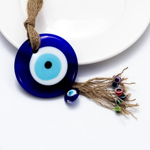 Detail of Turkish evil eye wall hanging with woven rope and colorful bead tassels