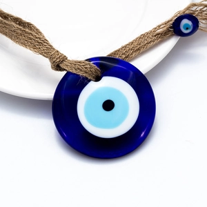 Macro detail of Nazar blue glass evil eye charm with rustic natural jute rope textures