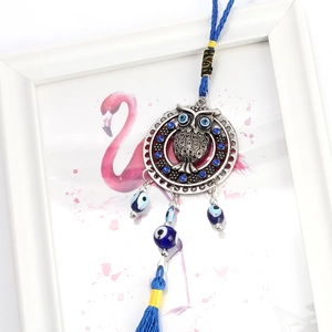 Detailed view of Owl Evil Eye pendant with blue rhinestones and silk tassel decor