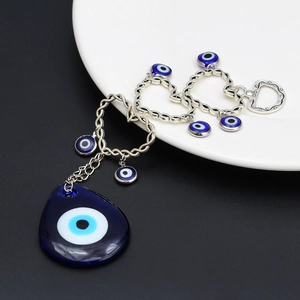 Dettaglio catena a cuore argento con ciondoli occhio greco blu e pendente a goccia