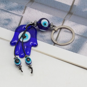 Detailaufnahme des Hamsa-Hand-Schlüsselanhängers mit blauen Glasaugen und Silberring