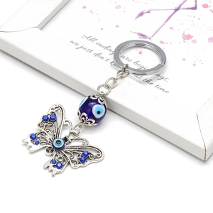 Blue rhinestone butterfly keychain with evil eye bead and silver metallic finish