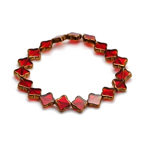 Vue détaillée des trèfles rouges avec bordures dorées sur un bracelet perlé chic
