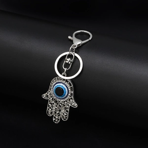 Detail of silver Hamsa Hand keychain with sparkling rhinestones and blue Evil Eye charm