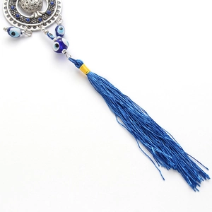 Detailed view of evil eye lucky charm with blue tassel and silver hollow pomegranate pendant