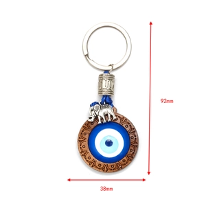 Detail view of Evil Eye charm with wooden trim and metal elephant, 92mm total height