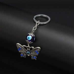 Detail of evil eye ceramic butterfly keychain with blue crystals on metal hardware