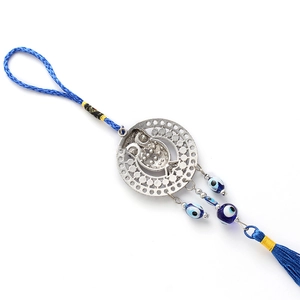 Macro detail of owl pendant featuring evil eye beads and blue tassel decorative fringe