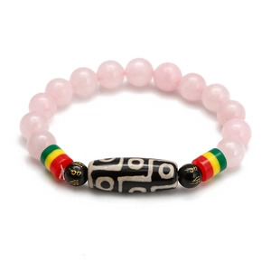 Vue macro du bracelet en perles de quartz rose et d'une perle Dzi aux veines de soie