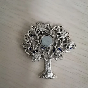 Detail view of the back of a life tree metal ornament featuring a magnetic clasp and blue beads