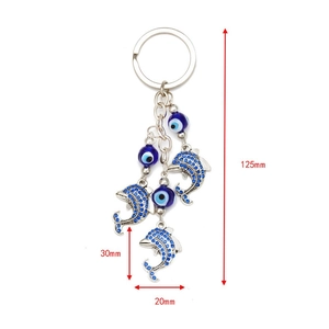 Silver dolphin keychain with blue evil eye beads and crystal charms on a white background
