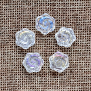 Vue détaillée de cinq perles florales transparentes irisées pour la création de bijoux