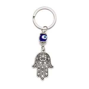 Detailed close-up of a Hamsa hand and blue evil eye bead on a silver keychain