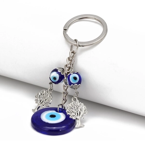 Detailed view of evil eye keychain with Tree of Life charms and blue glass beads