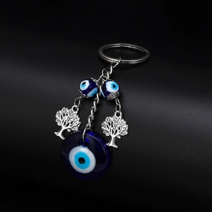 Detail of blue evil eye glass beads and silver tree of life charms on keychain