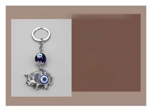 Close-up of silver elephant keychain with blue evil eye beads and crystal charms