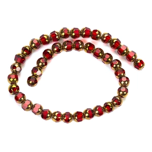 Vue détaillée de perles en cristal rouge facetté avec accents dorés pour la fabrication