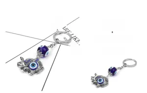 Detailed view of silver elephant keychain with blue evil eye beads and ornate carvings